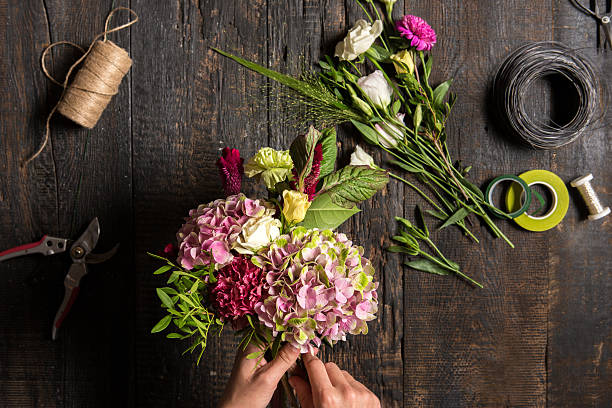 Professional florist creating beautiful flower arrangements in workshop